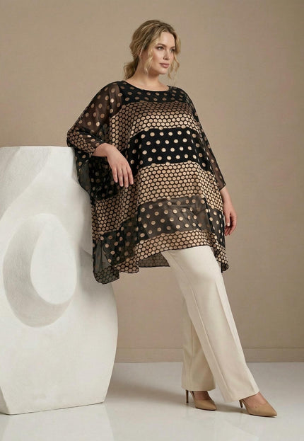 Официална черна макси туника тип пончо от шифон със златисти точки. Кадър в цял ръст на модел с бял панталон, позиращ до бяла скулптура.