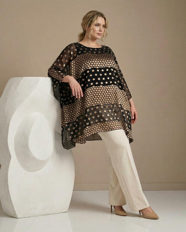 Официална черна макси туника тип пончо от шифон със златисти точки. Кадър в цял ръст на модел с бял панталон, позиращ до бяла скулптура.