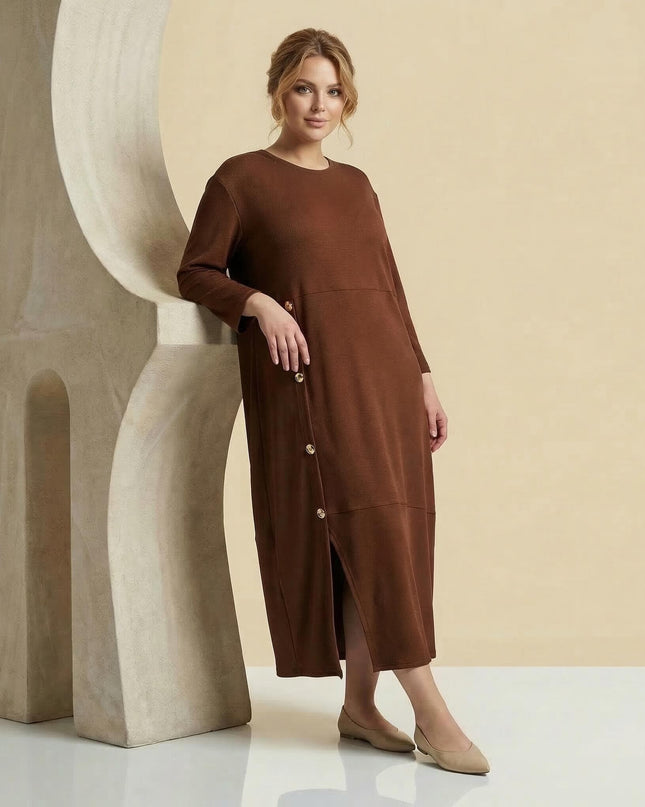 Официална макси рокля в кафяво с декоративни копчета и цепка, представена в цял ръст. Моделът е с 7/8 ръкави и елегантен силует.