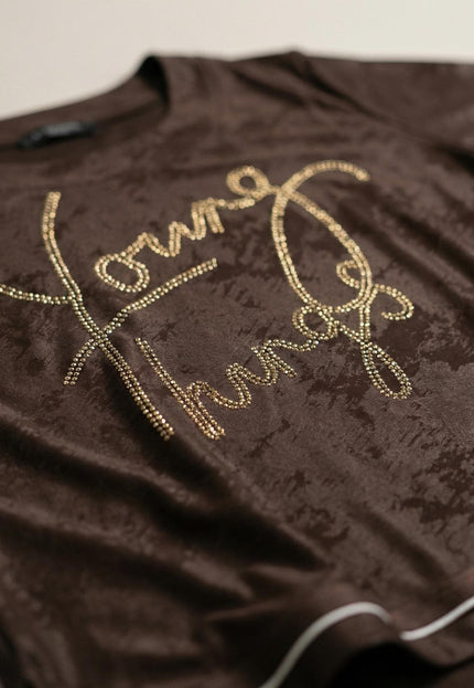 Детайл отблизо на кафява официална туника. Вижда се релефната материя, белият кант и красивият блестящ надпис от камъчета.