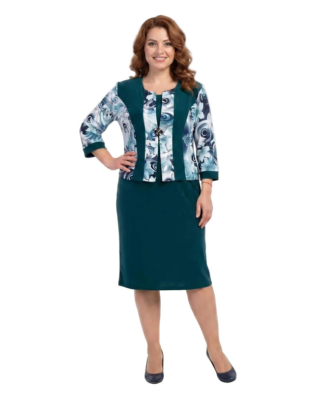 Цял ръст на жена в официална масленозелена рокля с флорални мотиви на бял фон.