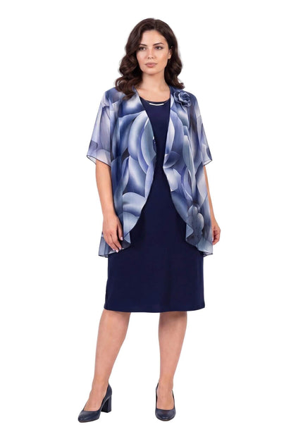 Официална тъмносиня рокля с права кройка и ефирна шифонена пелерина с флорален принт. Представена отпред в цял ръст на чисто бял фон.