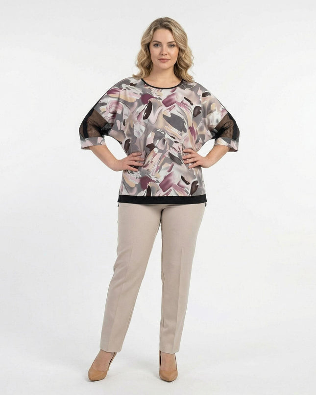 Елегантна туника големи размери с абстрактен десен и мрежести ръкави, съчетана с бежов панталон в цял ръст.
