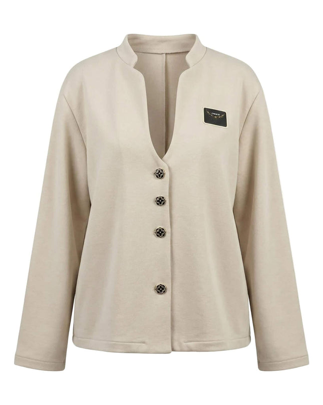 Официално бежово дамско сако с ефектно изрязано деколте, четири декоративни копчета и стилна малка емблема, заснето на бял фон.