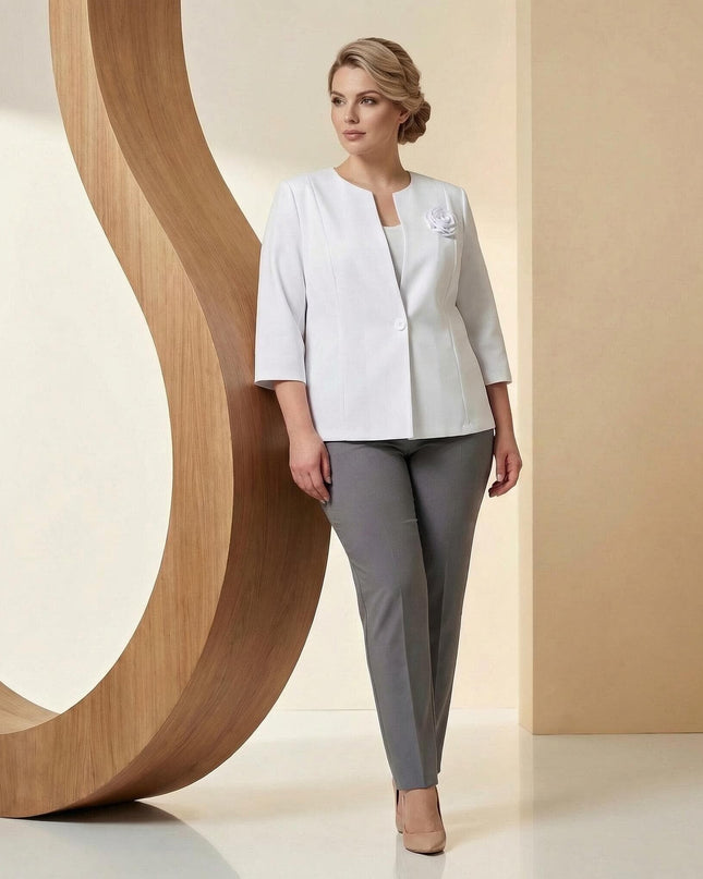 Официално бяло сако с роза и 7/8 ръкав макси мода, цял ръст, съчетано със сив панталон, представено от модел в елегантна студийна обстановка.