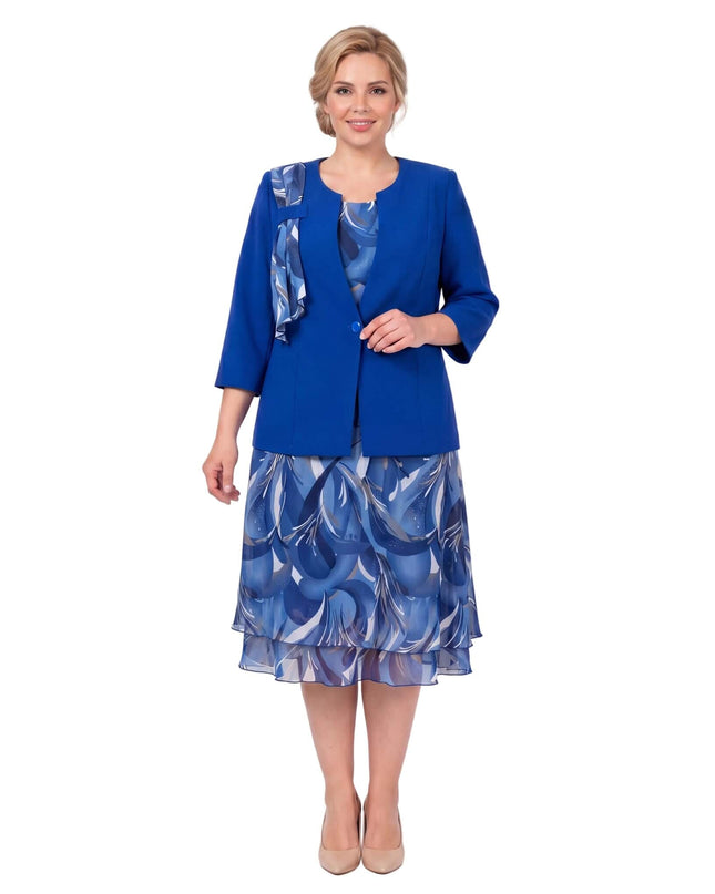Официален дамски костюм големи размери в кралскосин цвят с флорална шифонена рокля. Цял ръст на бял фон, показващ ефирния многопластов силует.