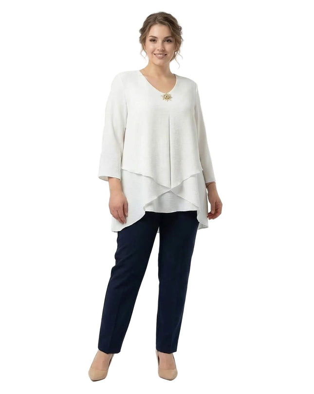 Официална бяла макси туника с асиметрична кройка и брошка, показана в цял ръст на бял фон.