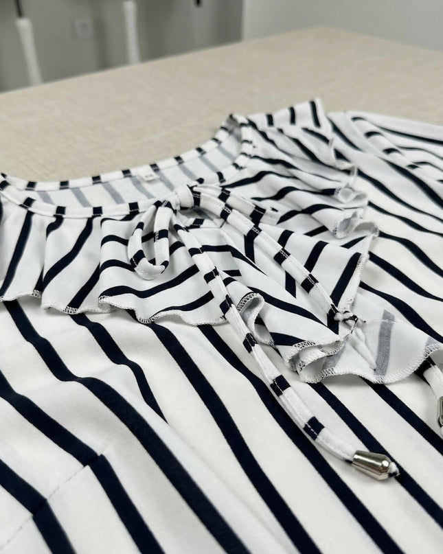 Детайл отблизо на официална бяла туника на тъмносиньо райе, показващ ефектното набрано деколте с връзки и метални накрайници.