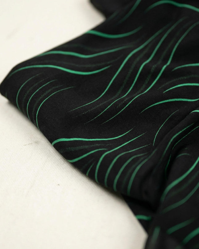 Детайлен кадър отблизо на официална черна макси туника, показващ текстурата на материята и декоративните вълнообразни елементи.