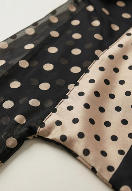 Детайл отблизо на официална черна макси туника тип пончо, показващ шев между прозрачен шифон със златисти точки и гладка материя.