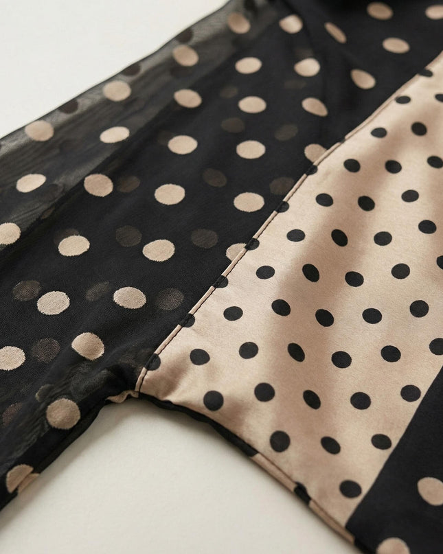 Детайл отблизо на официална черна макси туника тип пончо, показващ шев между прозрачен шифон със златисти точки и гладка материя.