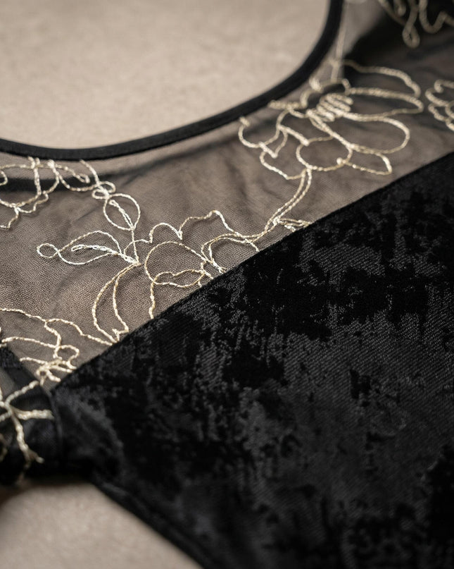 Детайл отблизо на официална черна туника големи размери, показващ ефектна мрежа със златиста флорална бродерия и текстурирана материя.