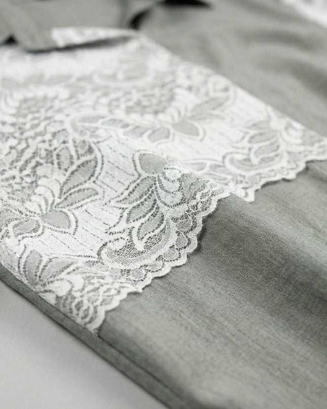 Детайлен кадър на официална макси риза от лен в цвят каки, показващ отблизо текстурата на материята и елегантните елементи от бяла дантела.