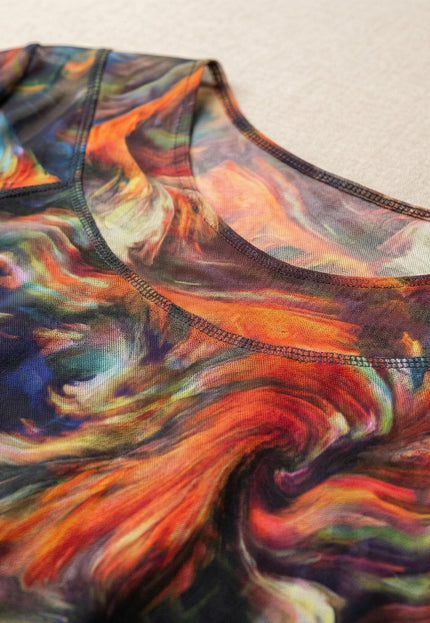 Детайл отблизо на деколтето на официална макси туника, показващ фината структура на материята и абстрактния принт в преливащи червени и многоцветни нюанси.