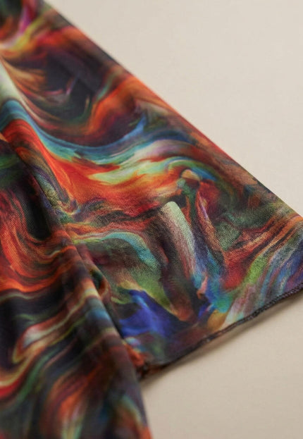 Детайл отблизо на материята на официална макси туника от шифон, изобразяващ преливащи се цветове в абстрактен десен и фин шев на ръкава.