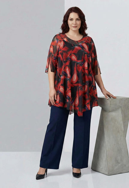 Официална макси туника от цветен шифон с асиметрична кройка и преливащи червени нюанси, заснета в цял ръст върху модел до декоративна колона.