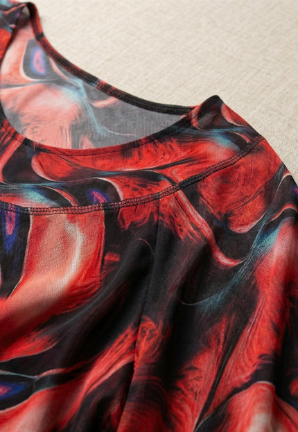 Детайл отблизо на облото деколте и материята на официална макси туника от цветен шифон с абстрактен принт в червено и черно.