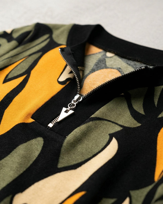 Детайл отблизо на сребрист цип и деколте на официална разкроена макси туника с шарен десен в черно, зелено и жълто.