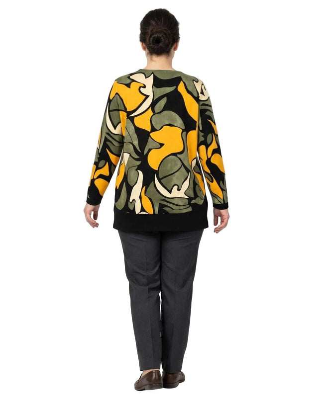 Официална разкроена макси туника в шарен десен с абстрактни мотиви в зелено и жълто, заснета в поглед отзад. Моделът завършва с широк черен кант.