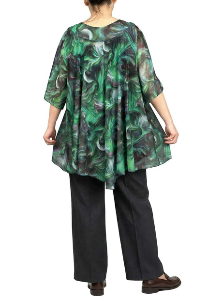 Официална разкроена макси туника с абстрактен зелен принт, изглед отзад. Моделът демонстрира свободната асиметрична кройка и ефирната падаща материя.