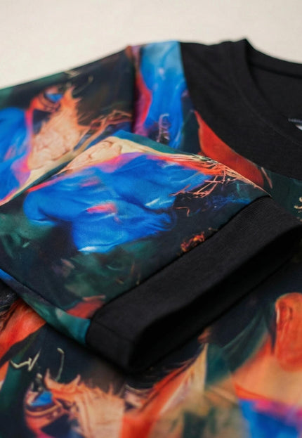 Детайл отблизо на ръкава и деколтето на официална разкроена туника, показващ цветния абстрактен принт и черния завършващ маншет.