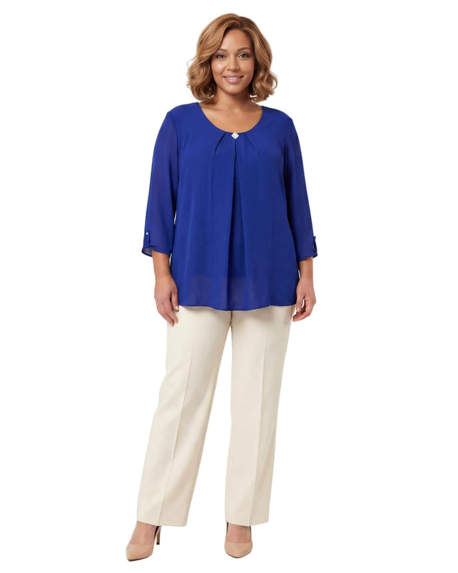 Елегантна разкроена туника от шифон в кралскосин цвят с декоративна брошка на деколтето, показана в цял ръст върху модел.