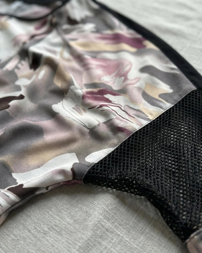 Детайл отблизо на официална туника големи размери, показващ ръкав с черна мрежеста платка и абстрактен шарен десен.