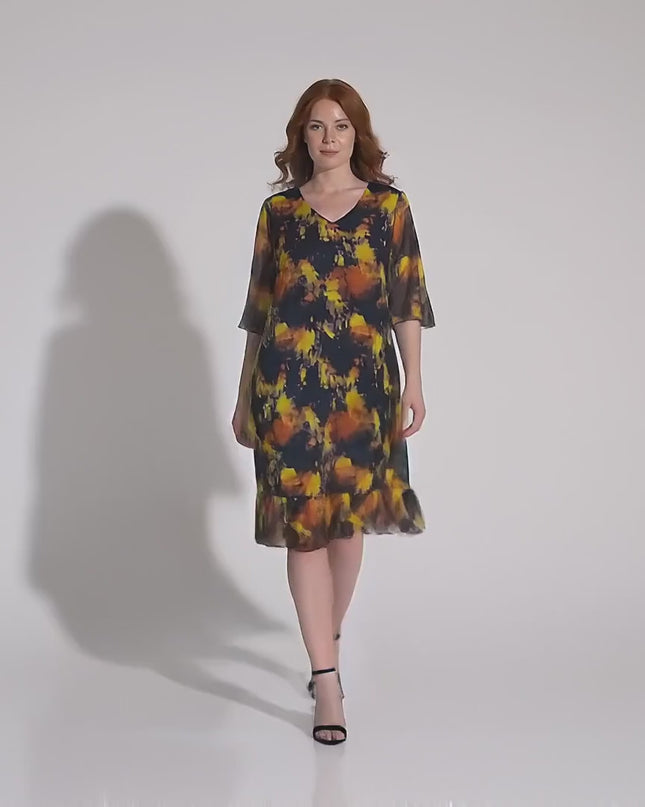 Модел носи Черна официална шифонена рокля големи размери и върви бавно към камерата в студийна среда на неутрален фон