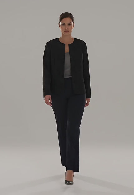 Видео в студио на неутрален фон, в което плюс сайз модел върви бавно към камерата, облечена в Официално черно сако големи размери с ефектна релефна текстура