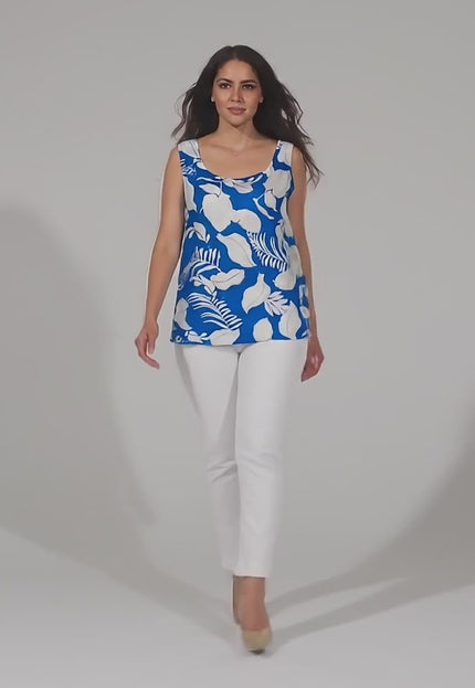 Видео в студийна среда с неутрален фон, в което плюс сайз модел върви бавно към камерата, носейки Свободен дамски топ в големи размери с тропически принт