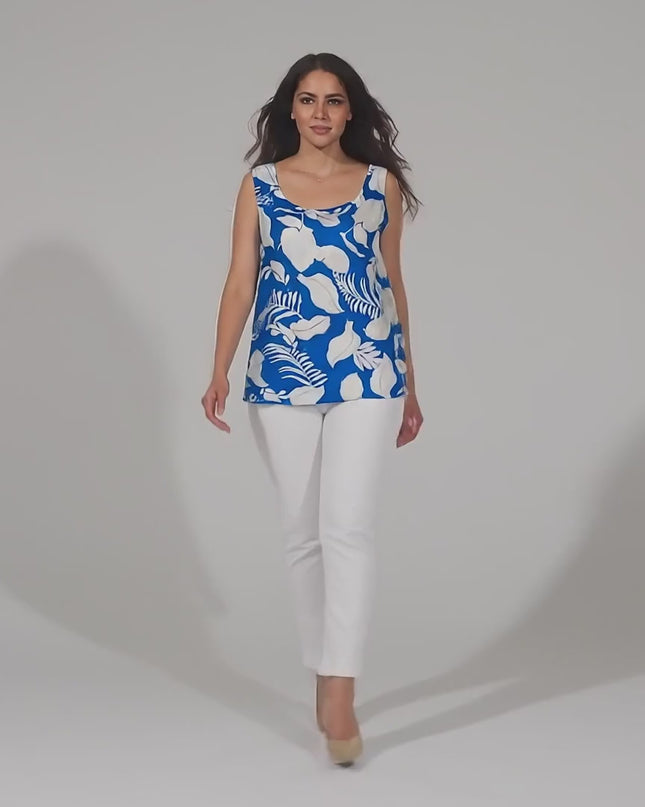 Видео в студийна среда с неутрален фон, в което плюс сайз модел върви бавно към камерата, носейки Свободен дамски топ в големи размери с тропически принт