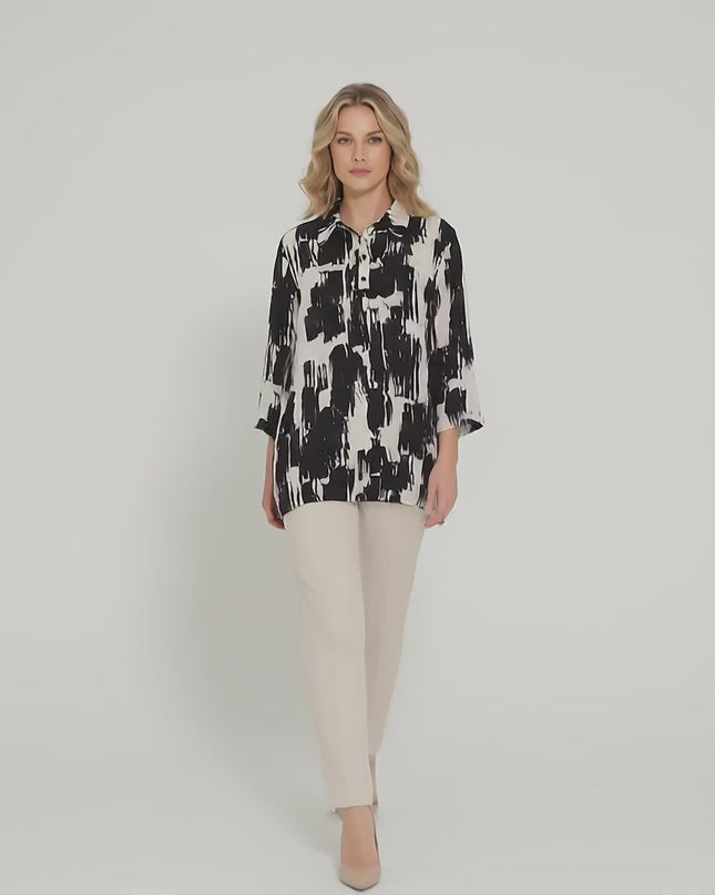 Студийно видео, в което макси модел върви бавно към камерата, носейки Елегантна официална макси риза в черно и бяло със свободен силует