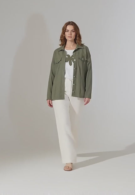 Студийно видео представяне на неутрален фон, в което женски модел плюс размер върви бавно към камерата, облечена в Дамски комплект от две части с тениска с щампа и сако каки