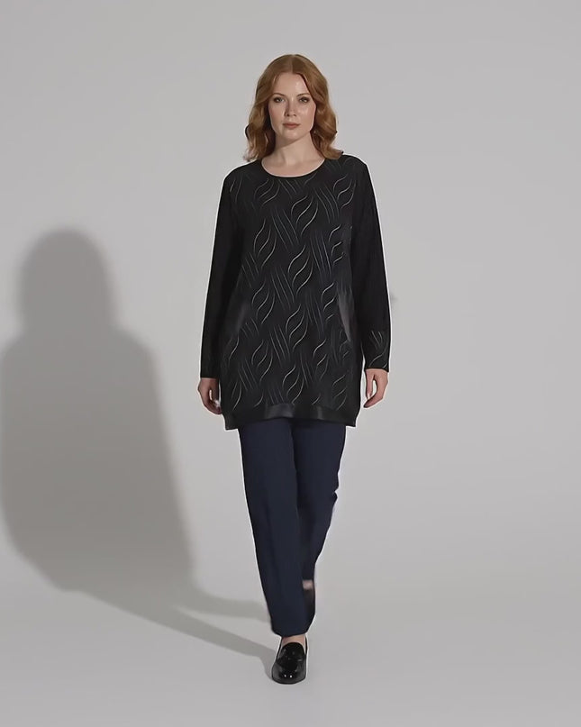 Видео представяне в студио на неутрален фон, показващо плюс сайз модел, който върви бавно към камерата и е облечен с Официална черна макси туника с джобове и елементи от еко кожа