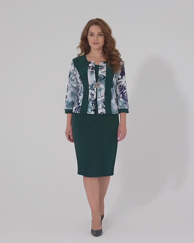 Модел с пищни форми върви бавно към камерата в студийна среда на неутрален фон, носейки Официална масленозелена рокля големи размери с флорални мотиви