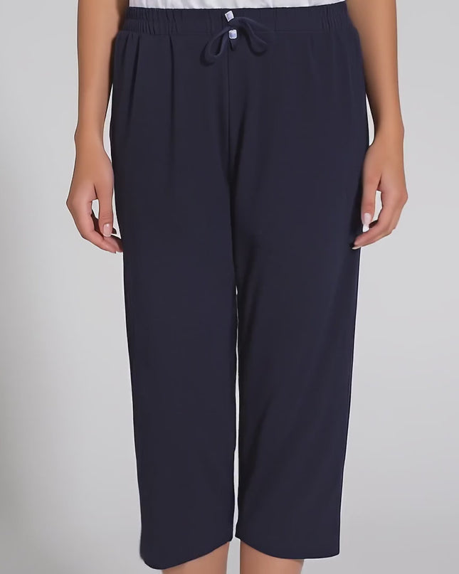 Продуктово видео в студийна среда на неутрален фон, показващо плюс сайз модел, който върви бавно към камерата и носи Дамски панталони в големи размери - Еластични