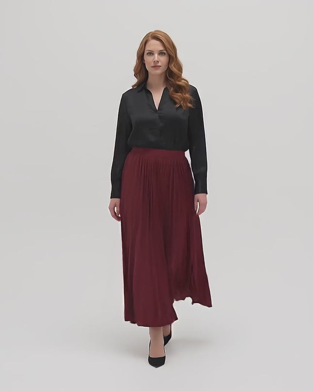 Видео на плюс размер модел в студийна среда на неутрален фон, който върви бавно към камерата, носейки Официална разкроена пола големи размери в бордо