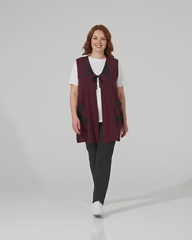 Видео на модел, който върви към камерата и представя Разкроен макси елек в цвят бордо с елементи от еко кожа в студио