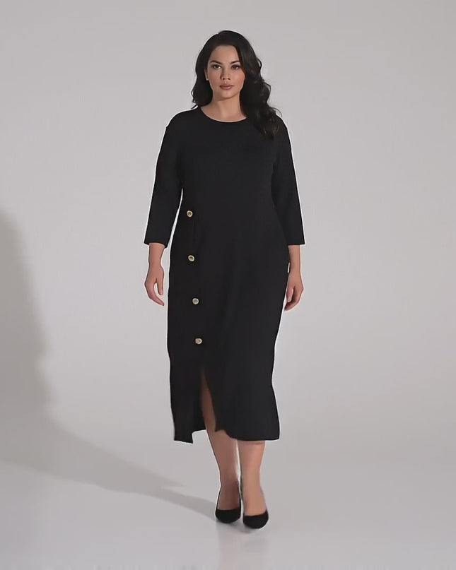 Жена модел с пищни форми носи Разкроена официална черна рокля големи размери и върви бавно към камерата в студио с неутрален фон