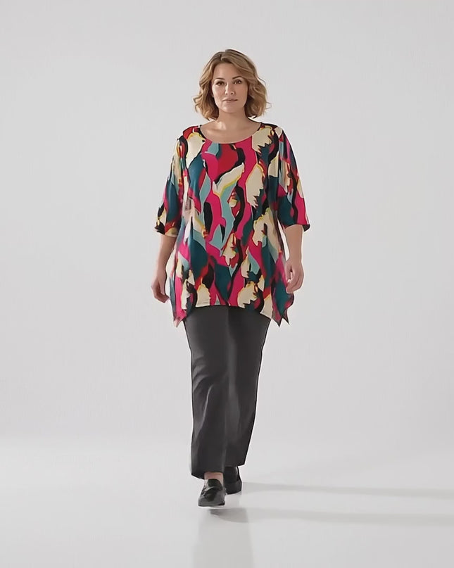 Продуктово видео в студийна среда на неутрален фон, показващо плюс сайз модел, която върви бавно към камерата и е облечена с Дълга лятна макси туника в шарен абстрактен принт