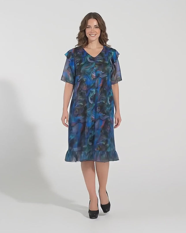 Студийно видео с неутрален фон, на което плюс сайз модел върви бавно към камерата, носейки Шарена официална рокля големи размери с ефектен ръкав и шифон