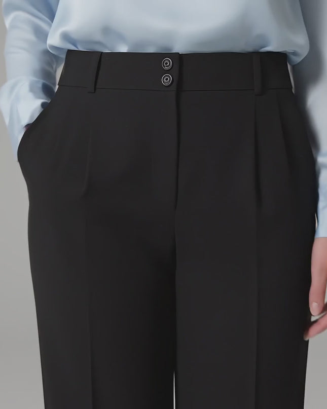 Видео в студийна среда с неутрален фон, на което плюс размер модел върви бавно към камерата, носейки Официален черен панталон големи размери с права кройка