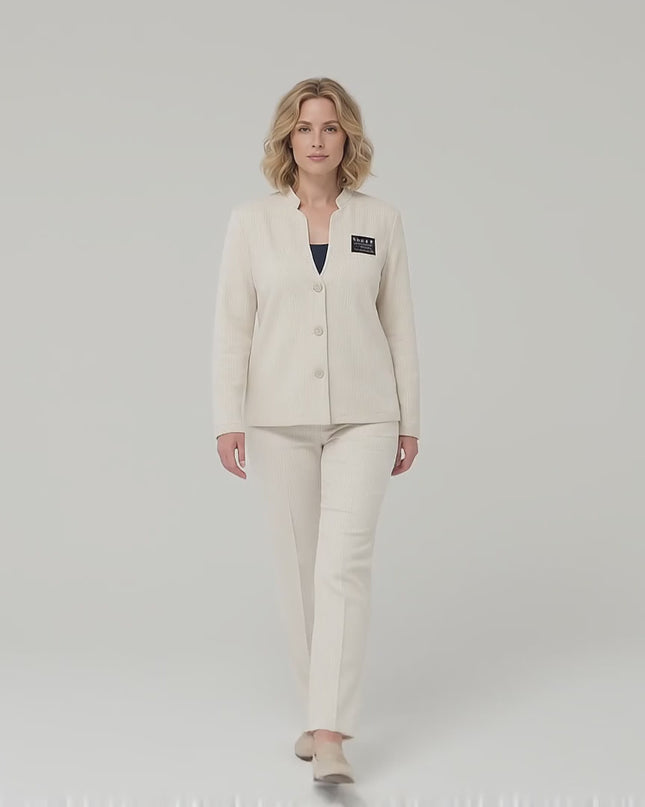 Видео представяне в студио на неутрален фон, където модел върви бавно към камерата, носейки Официално бежово дамско сако с ефектно деколте големи размери