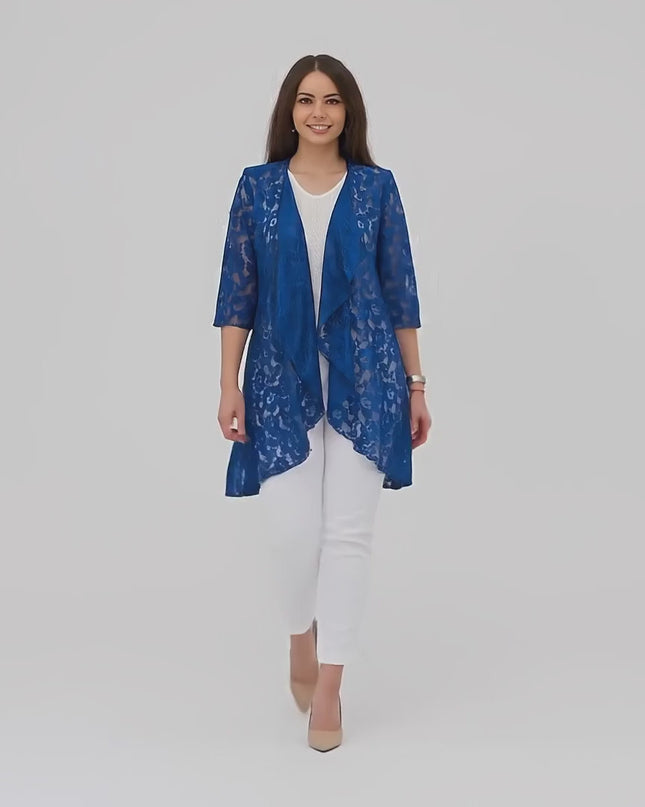 Продуктово видео в студио, показващо макси модел, който върви бавно към камерата, облечен с Официален макси дантелен блейзър в кралскосин цвят