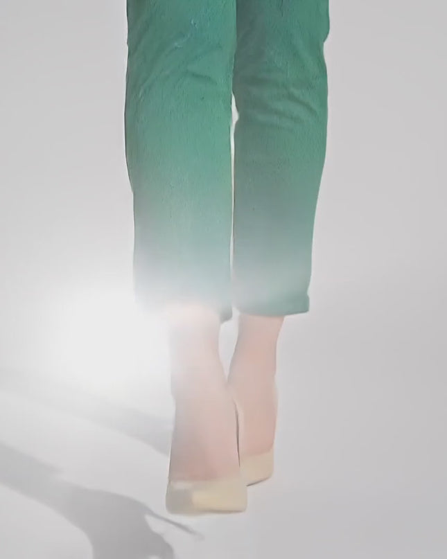 Продуктово видео в студио показващо как макси модел носи Елегантен зелен макси панталон на черни точки и еластична талия и върви бавно към камерата на неутрален фон