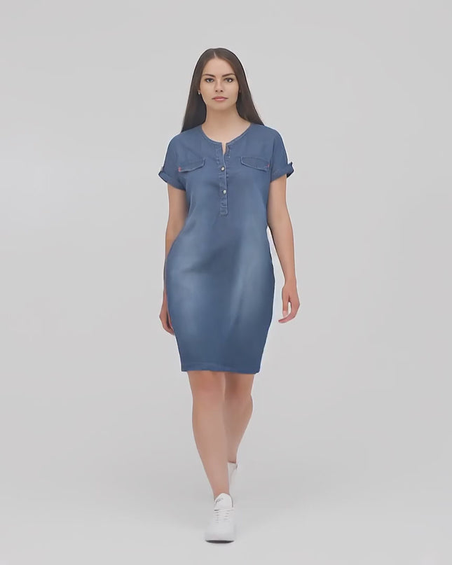 Плюс сайз модел в студио върви бавно към камерата, облечен в Дънкова рокля с джобчета в големи размери - Комфорт и стил