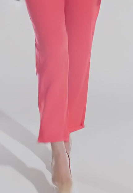 Жена модел върви бавно към камерата в студийна среда с неутрален фон, носейки Коралов ленен панталон с джобове и връзки в големи размери