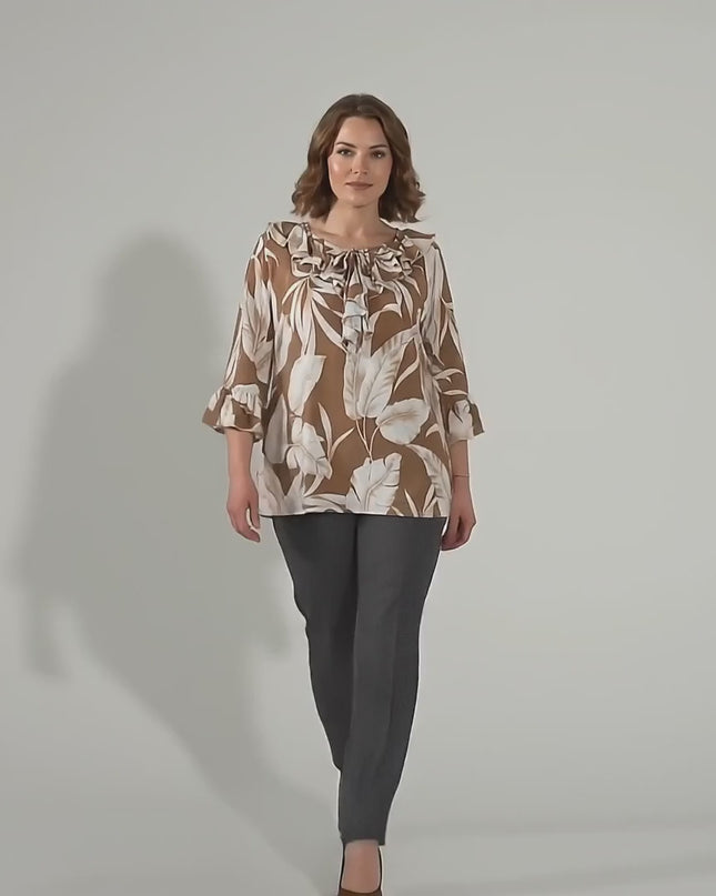 Студийно видео с неутрален фон, в което плюс сайз модел върви бавно към камерата, носейки Официална разкроена туника в светлокафяво големи размери