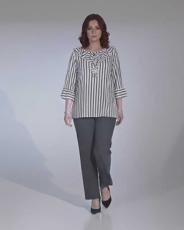 Видео презентация в студио на неутрален фон, показваща плюс сайз модел, който върви бавно към камерата и е облечен с Официална бяла туника на тъмносиньо райе макси размери