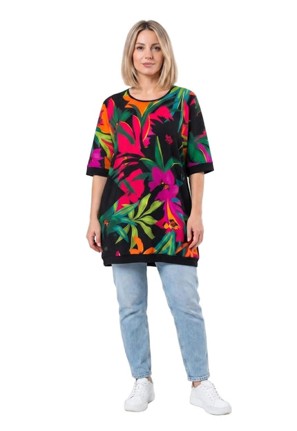Шарена лятна туника големи размери с ярък тропически флорален принт на черен фон. Изглед отпред в цял ръст на модел върху бял фон.